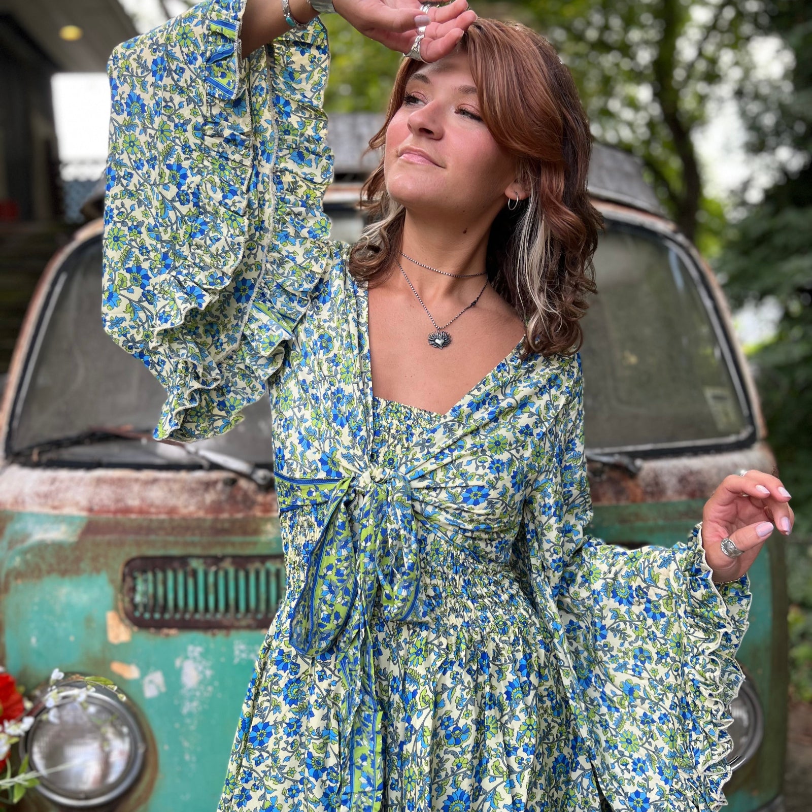 A woman wearing the green Hippie Bohemian Fairy Dress with Elastic Fairy Skirt in front of a vintage Volkswagen bus.