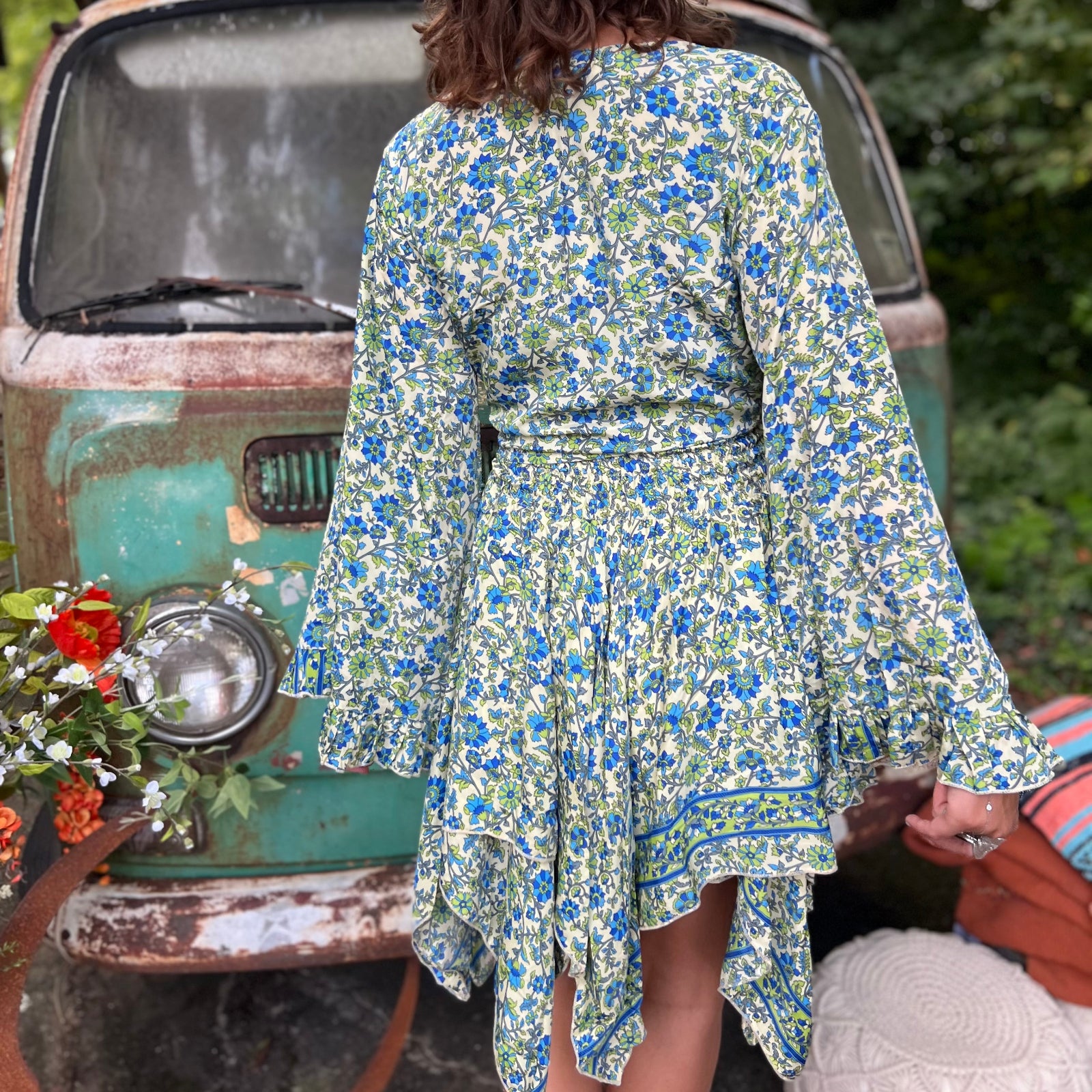 A woman wearing the green Hippie Bohemian Fairy Dress with Elastic Fairy Skirt in front of a vintage Volkswagen bus.
