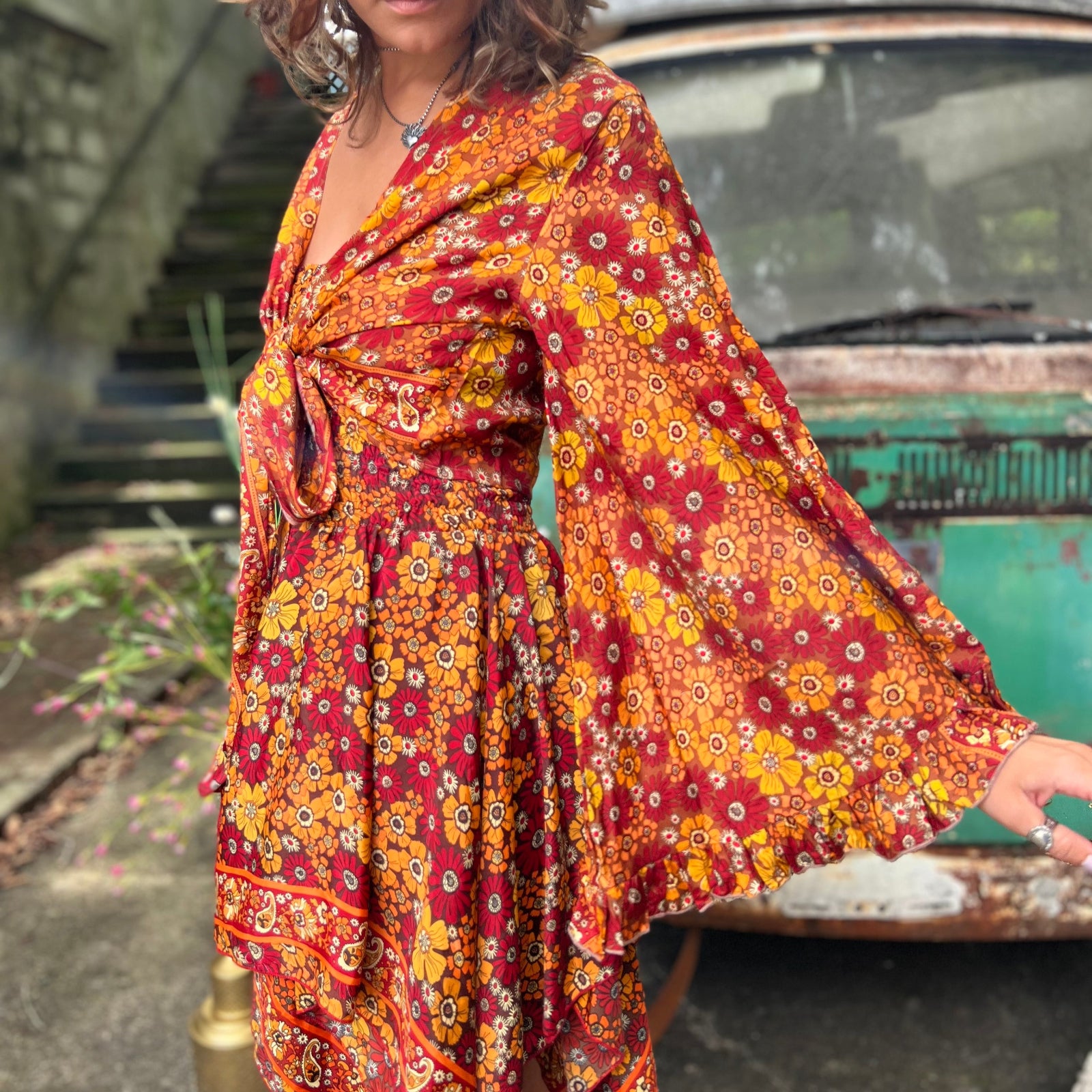 A woman wearing the red Hippie Bohemian Fairy Dress with Elastic Fairy Skirt in front of a vintage Volkswagen bus.