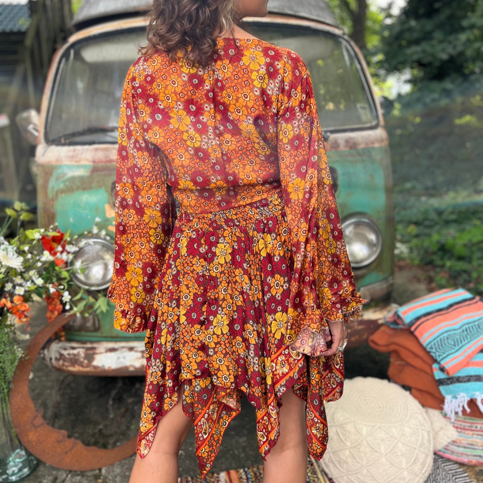 A woman wearing the red Hippie Bohemian Fairy Dress with Elastic Fairy Skirt in front of a vintage Volkswagen bus.