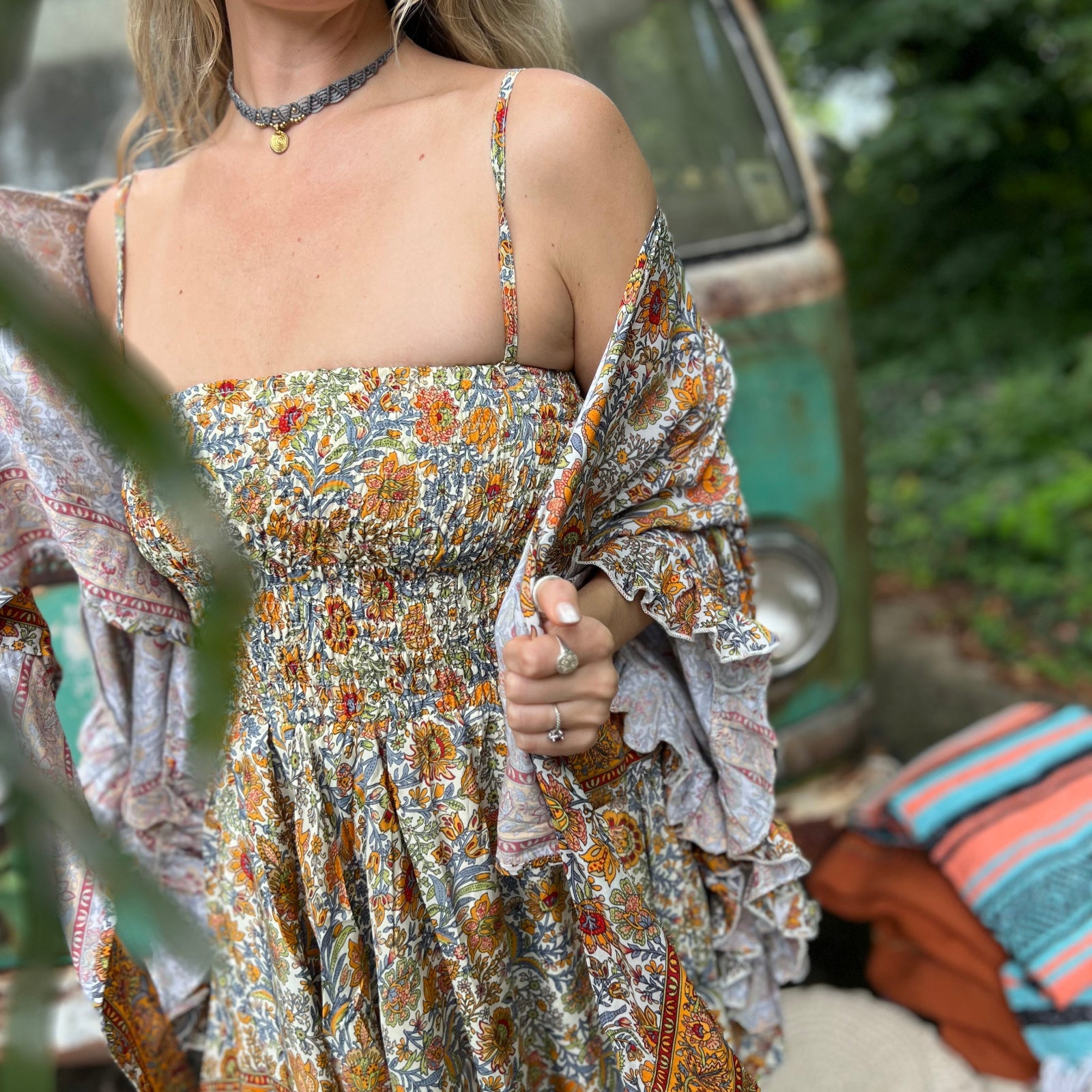 A woman wearing the orange and cream Hippie Bohemian Fairy Dress with Elastic Fairy Skirt in front of a vintage Volkswagen bus.