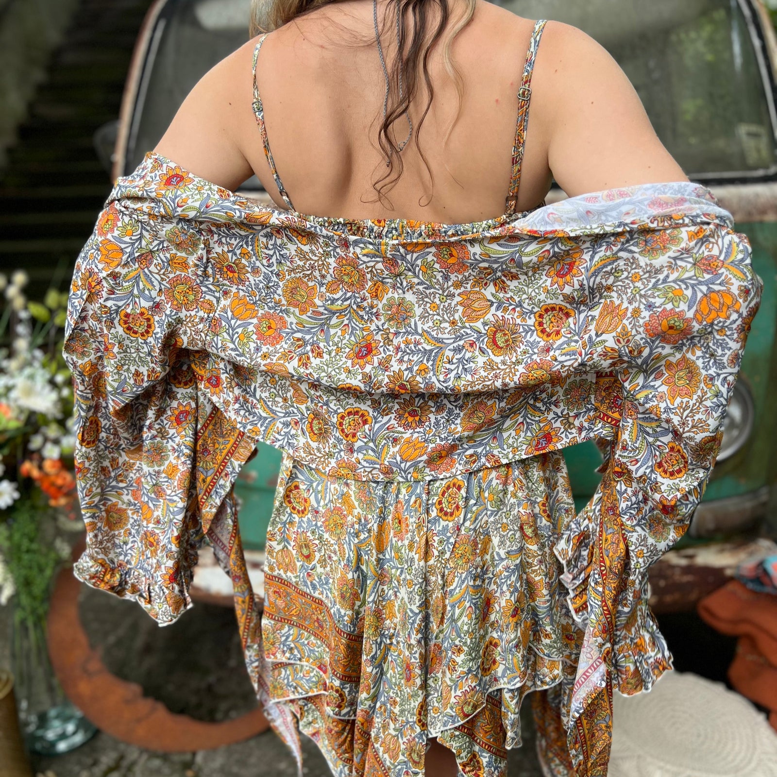 A woman wearing the orange and cream Hippie Bohemian Fairy Dress with Elastic Fairy Skirt in front of a vintage Volkswagen bus.