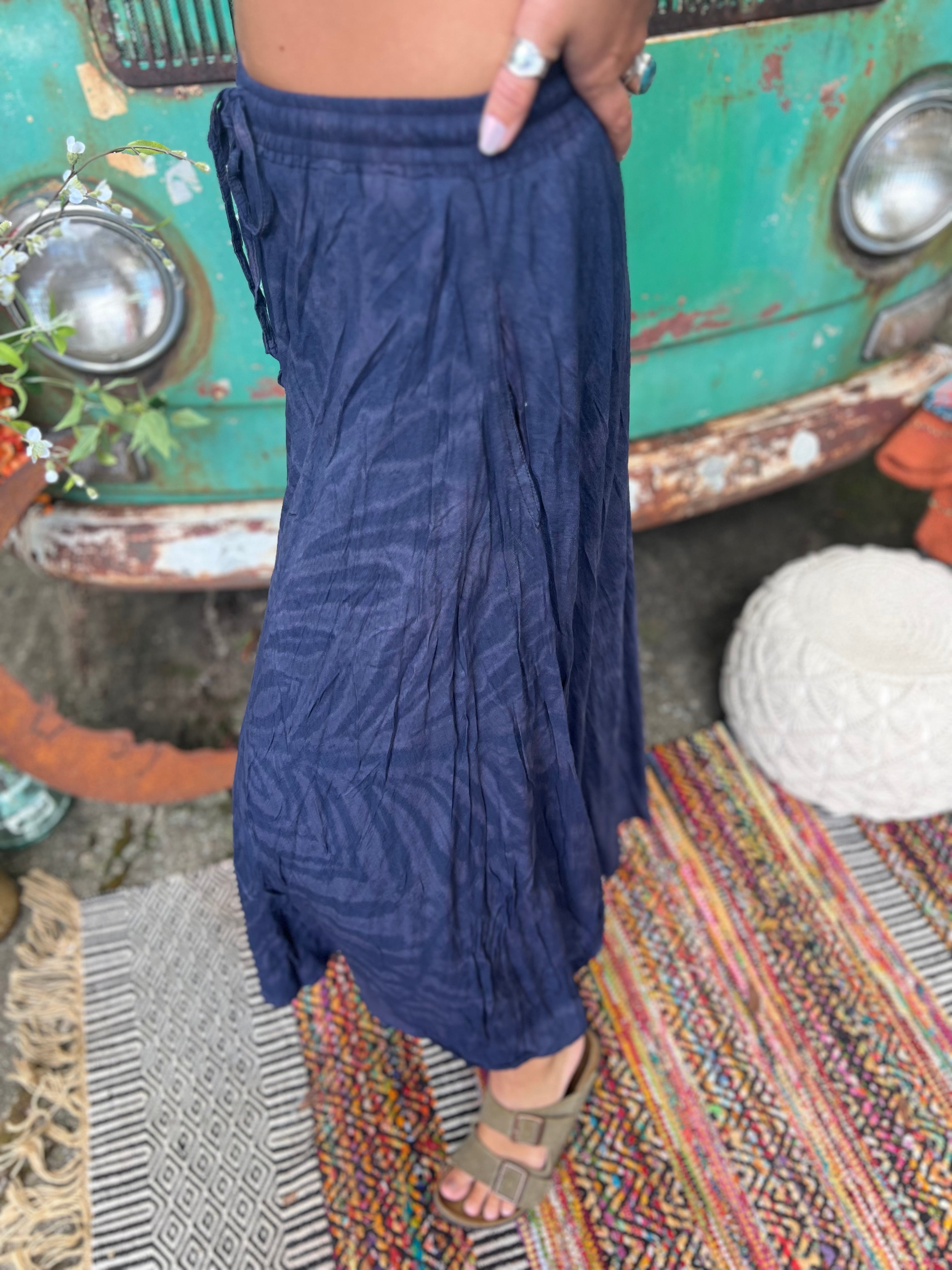 A woman wearing the navy Hippie Bohemian Hand Dyed Palazzo Pants in front of a vintage Volkswagen bus.