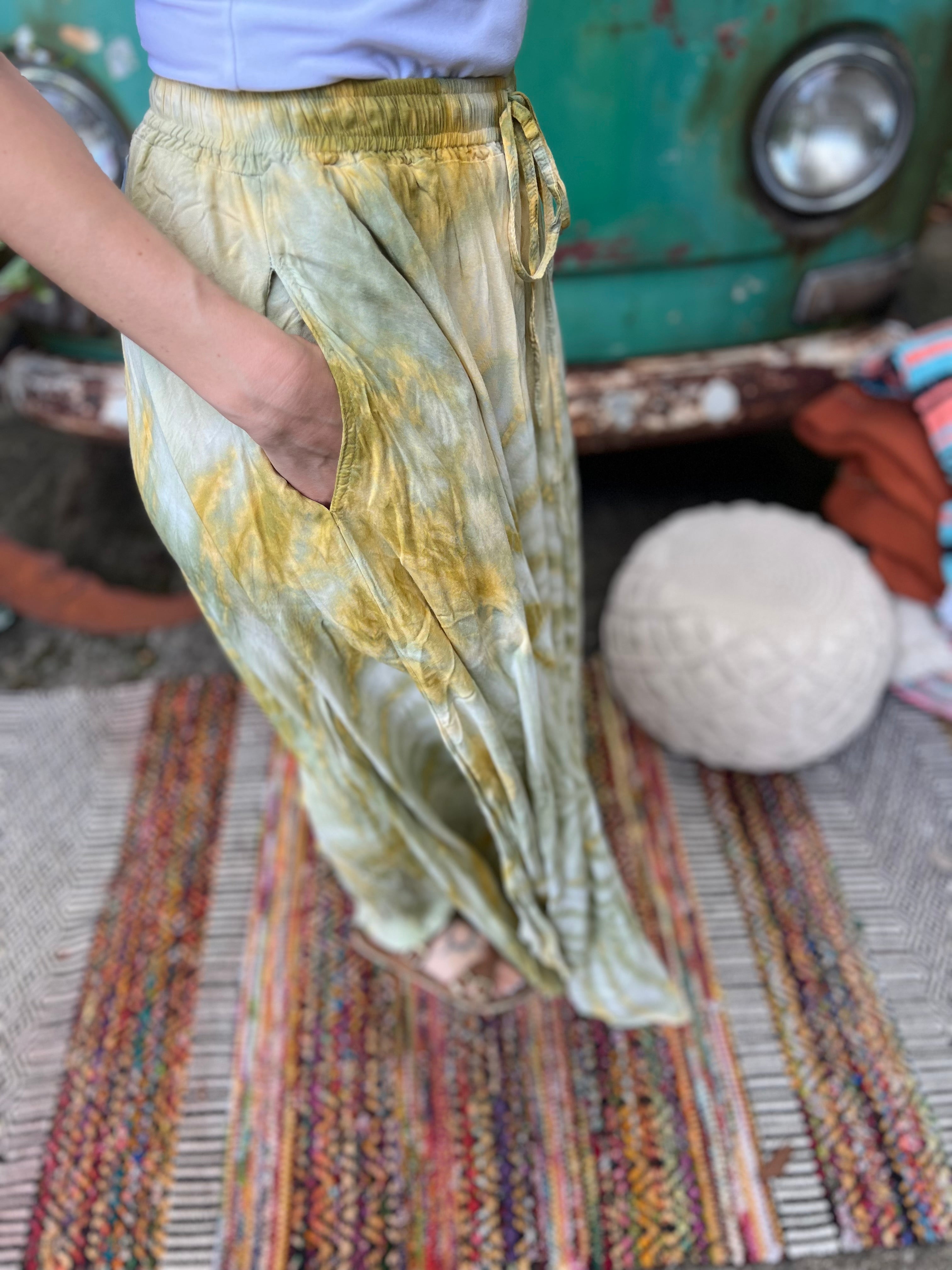 A woman wearing the green Hippie Bohemian Hand Dyed Palazzo Pants in front of a vintage Volkswagen bus.