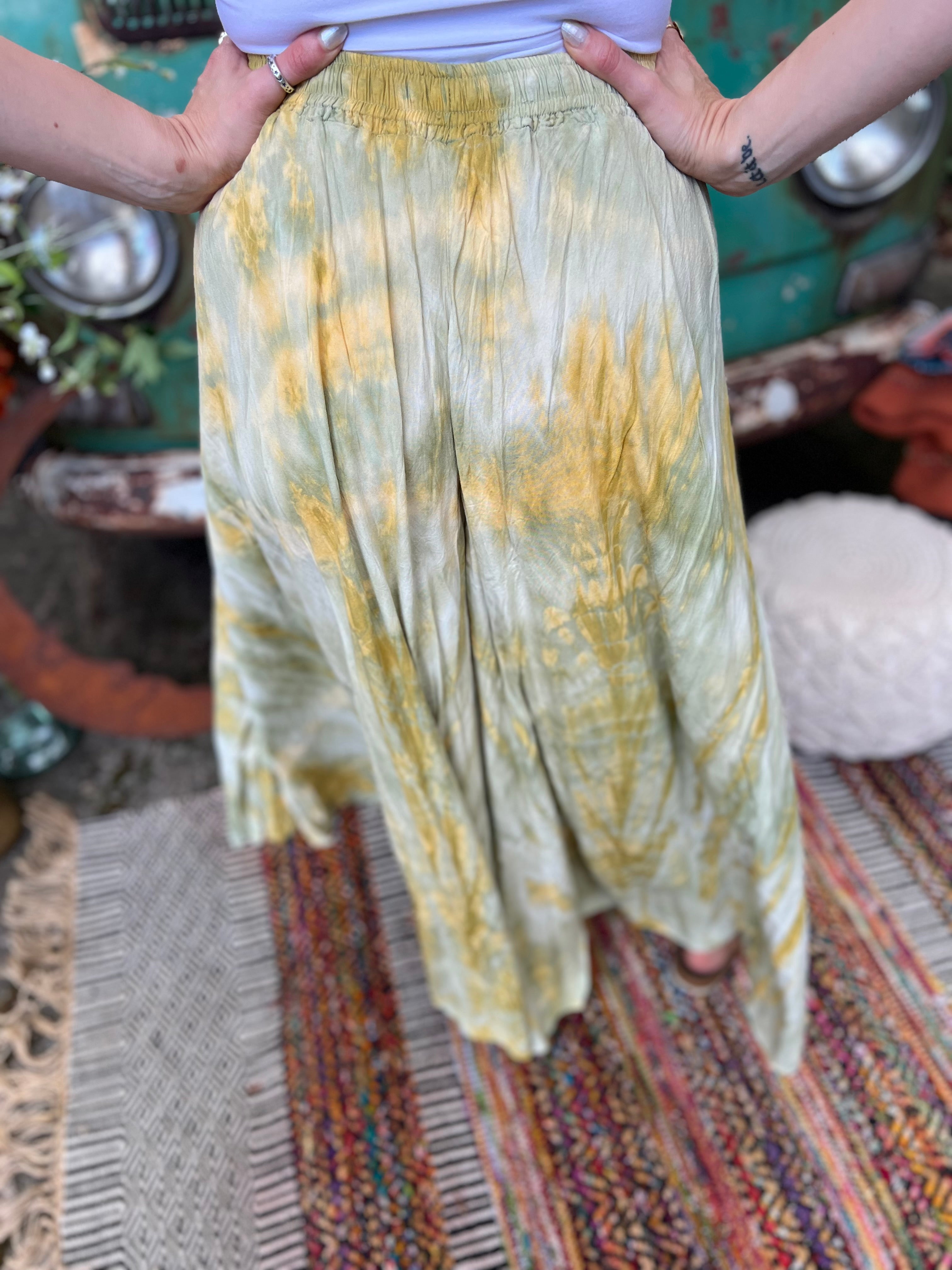 A woman wearing the green Hippie Bohemian Hand Dyed Palazzo Pants in front of a vintage Volkswagen bus.