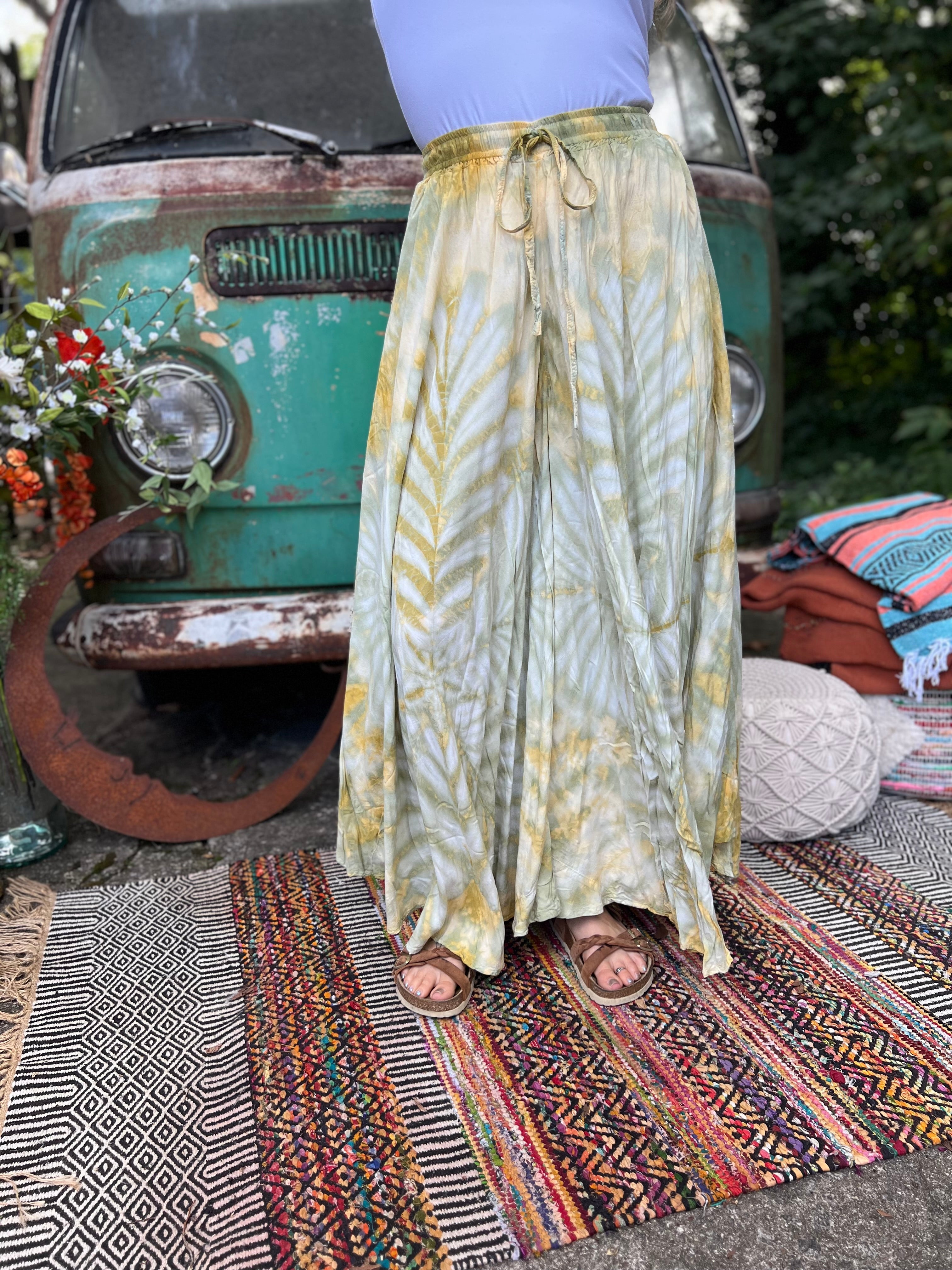 A woman wearing the green Hippie Bohemian Hand Dyed Palazzo Pants in front of a vintage Volkswagen bus.