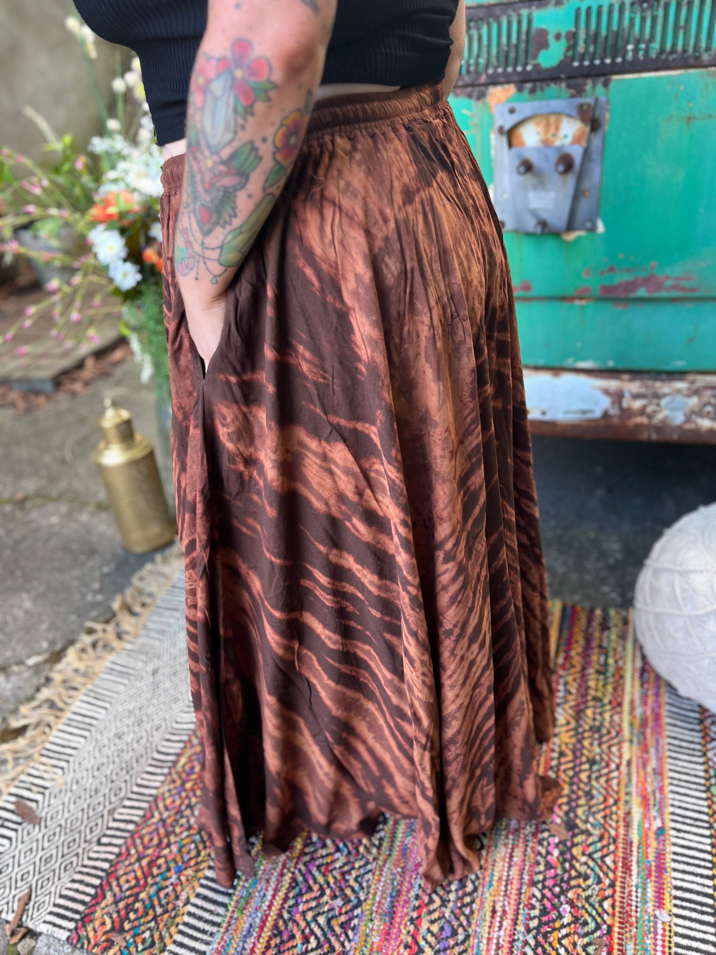 A woman wearing the brown Hippie Bohemian Hand Dyed Palazzo Pants in front of a vintage Volkswagen bus.