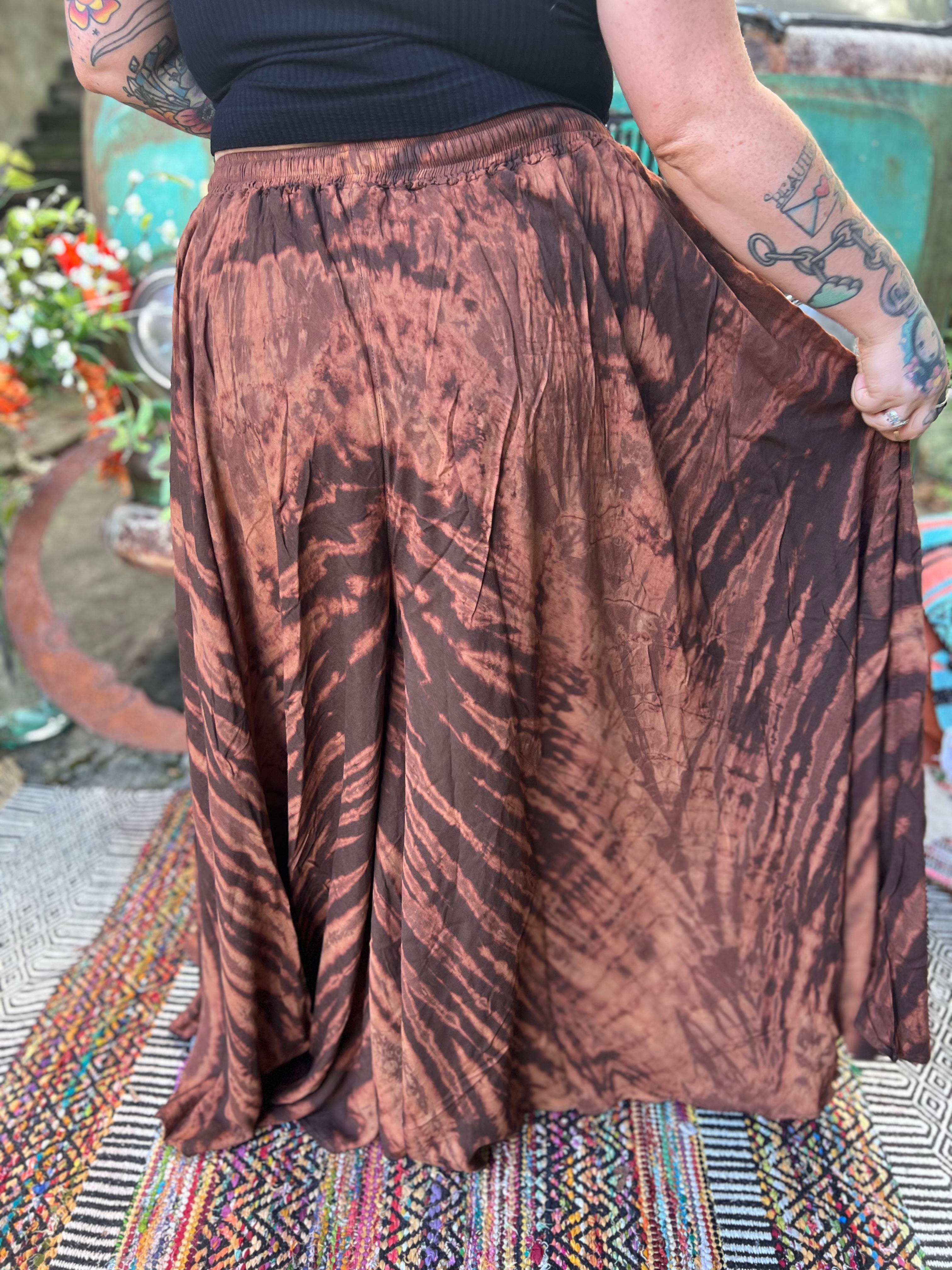 A woman wearing the brown Hippie Bohemian Hand Dyed Palazzo Pants in front of a vintage Volkswagen bus.