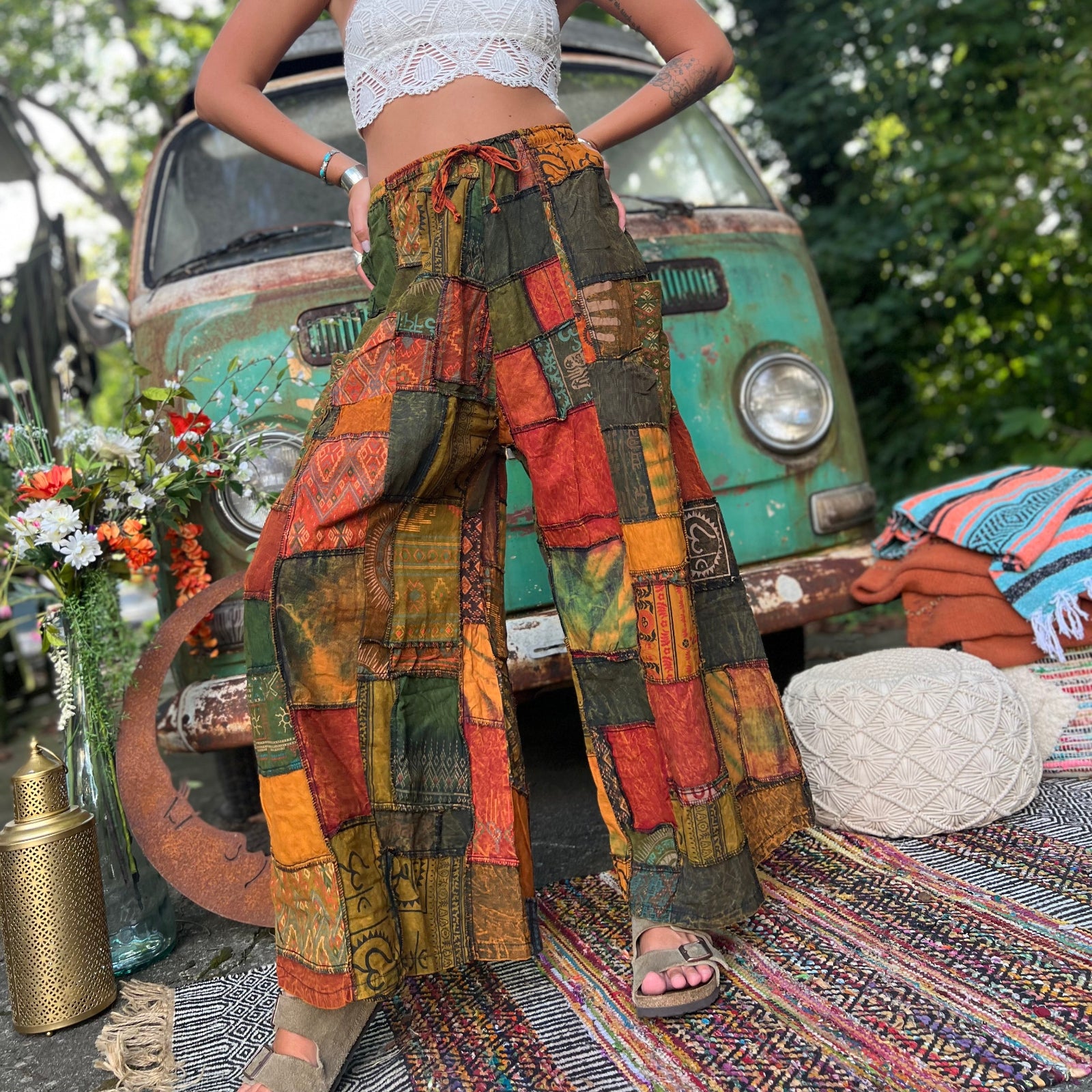A woman wearing the Bohemian Patchwork Flare Wide Leg Pants in front of a vintage Volkswagen bus.