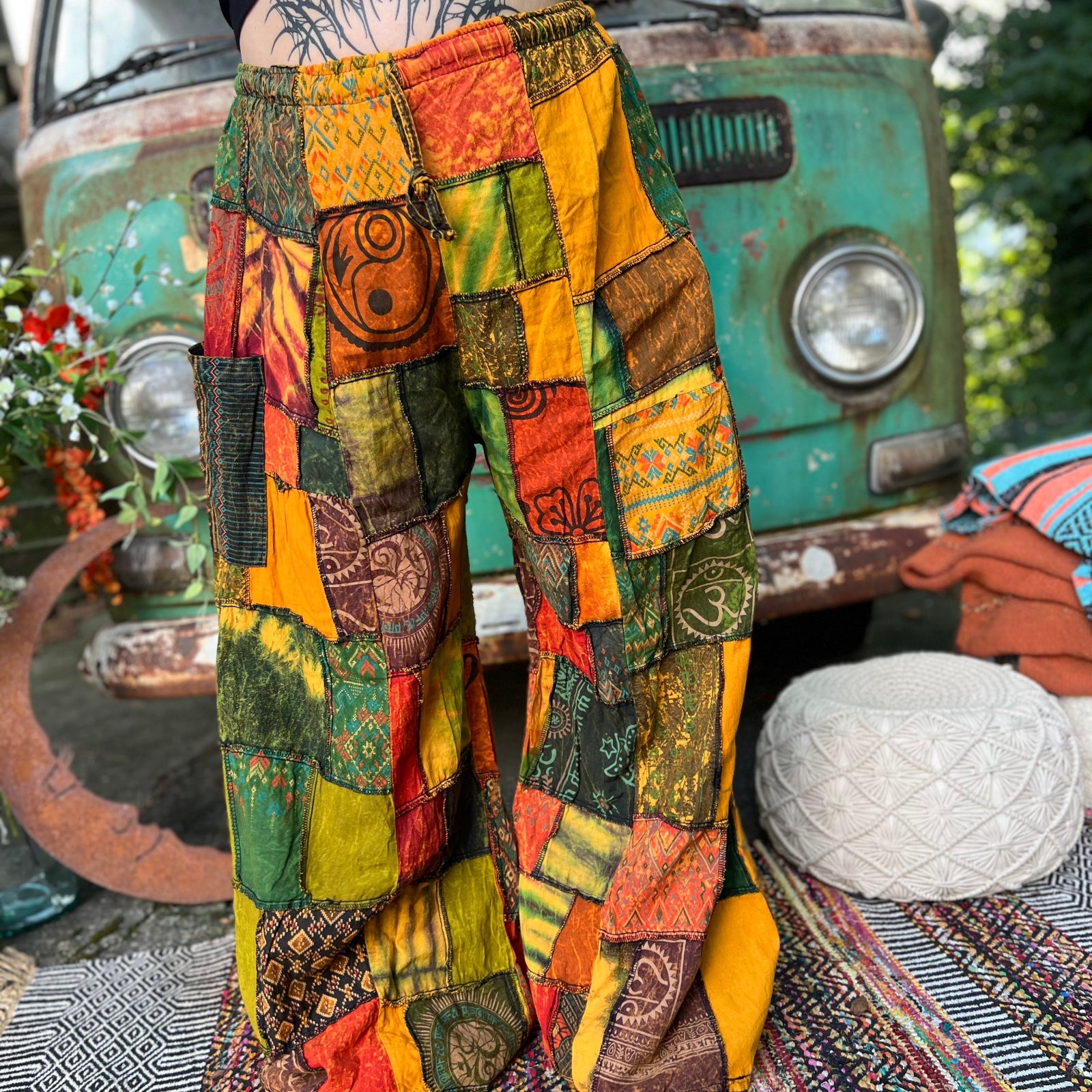 A woman wearing the Bohemian Patchwork Flare Wide Leg Pants in front of a vintage Volkswagen bus.