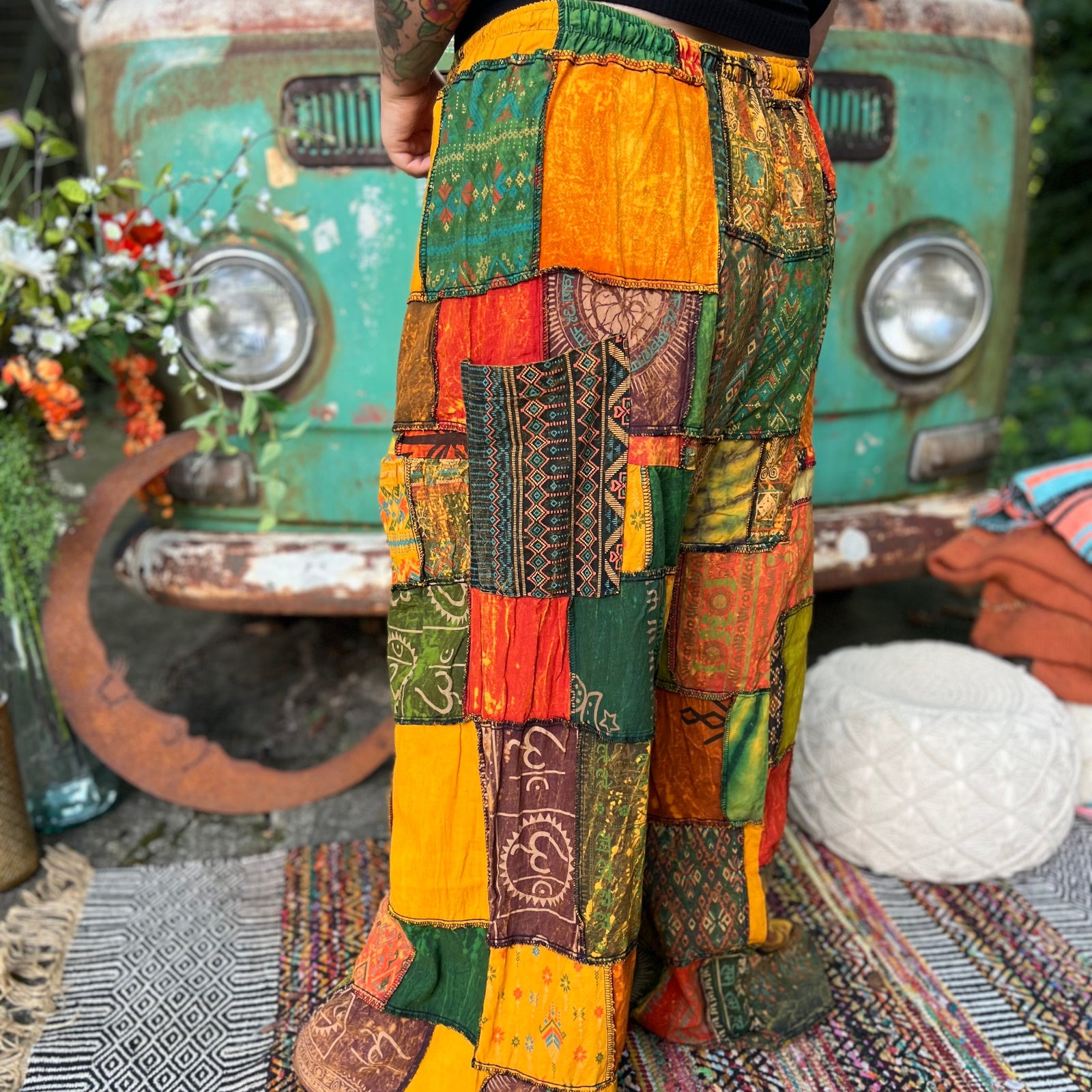A woman wearing the Bohemian Patchwork Flare Wide Leg Pants in front of a vintage Volkswagen bus.