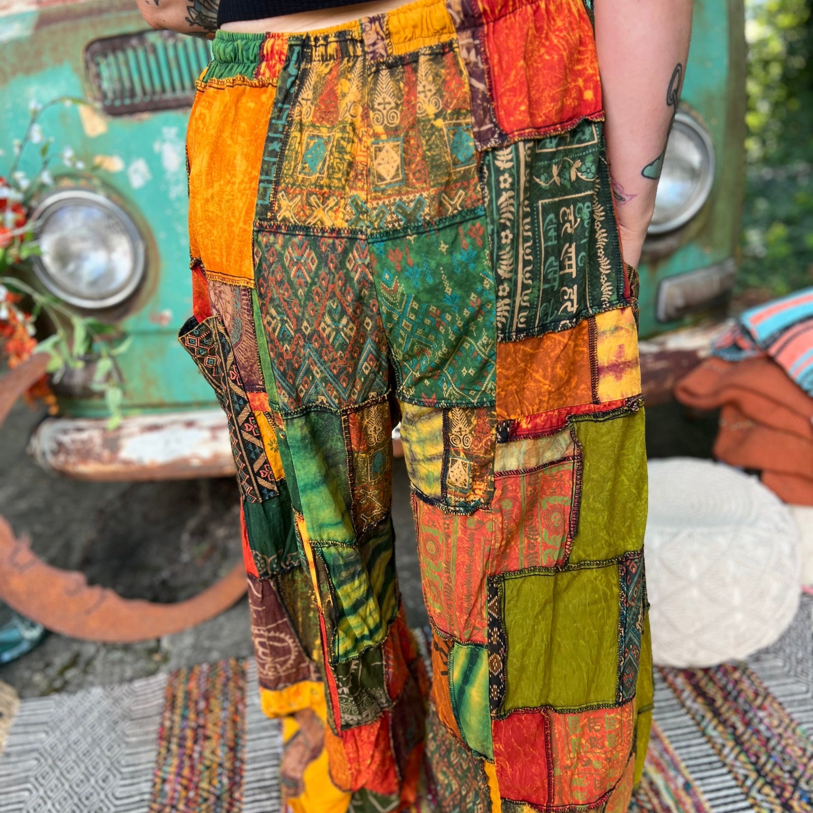 A woman wearing the Bohemian Patchwork Flare Wide Leg Pants in front of a vintage Volkswagen bus.