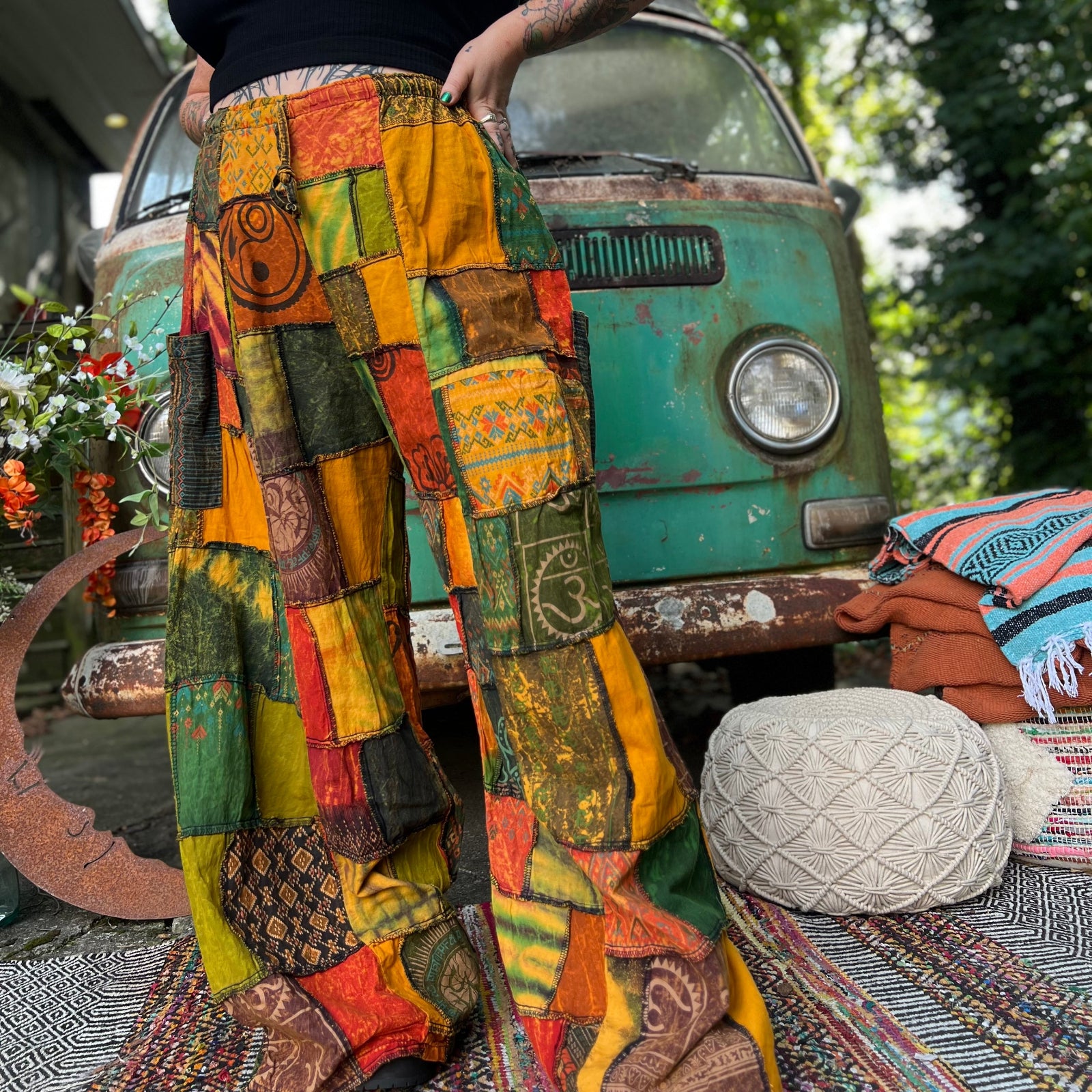 A woman wearing the Bohemian Patchwork Flare Wide Leg Pants in front of a vintage Volkswagen bus.