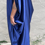 A woman wearing the Shadow Caftan in front of a white building.