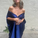 A woman wearing the Shadow Caftan in front of a white building.