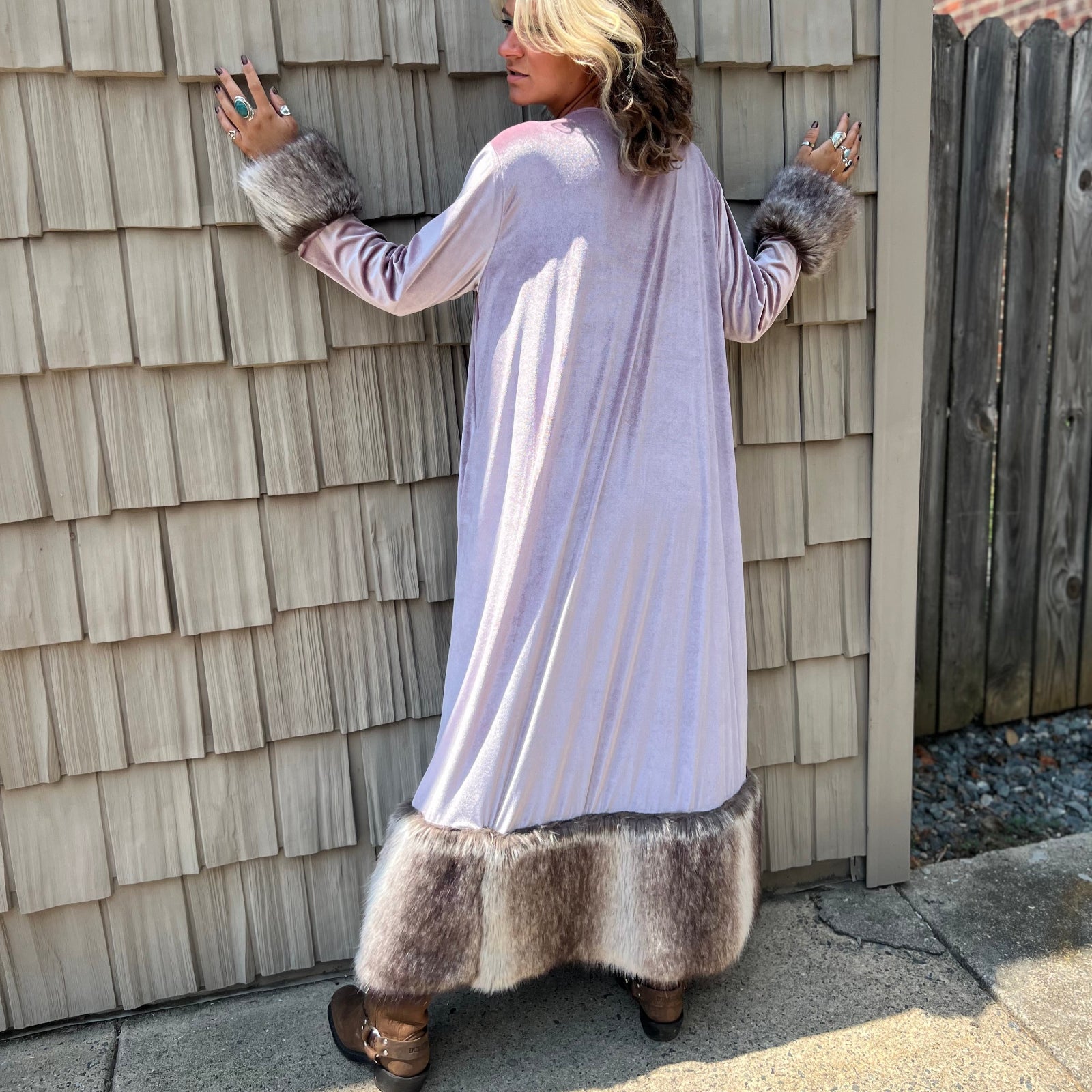 A woman wearing the Blush Velvet Faux Fur Jacket by Jennafer Grace with a black dress and brown boots.