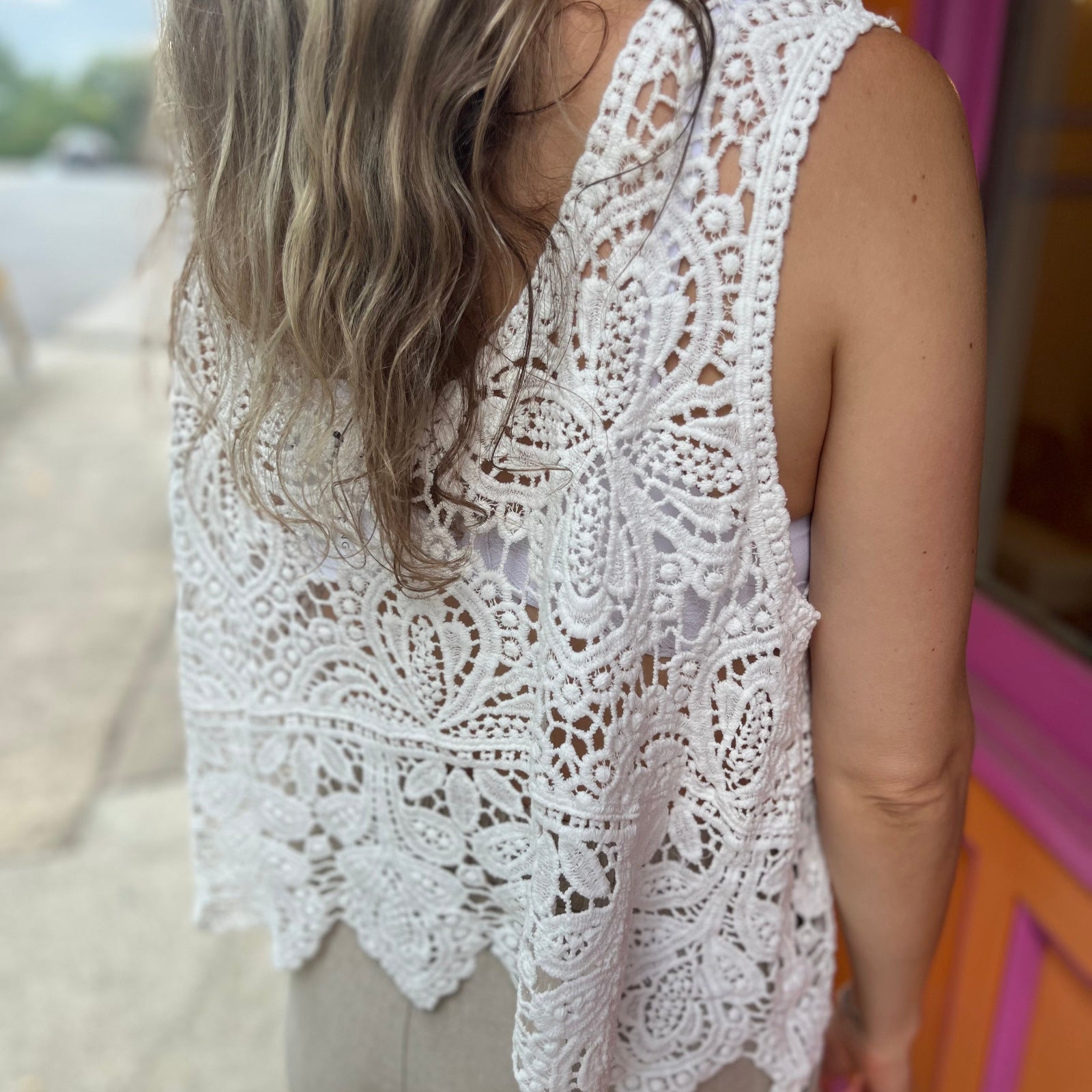 A woman wearing the Vintage Crochet Hollow-Out Tank Top with a beige linen pants.