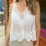 A woman wearing the white Bohemian Crochet Knit Sleeveless Tank with beige linen pants.