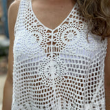 A woman wearing the white Bohemian Crochet Knit Sleeveless Tank with beige linen pants.