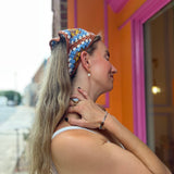 A woman wearing the Handmade Granny Square Crochet Headband around her head.