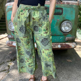 A woman wearing the Green Patch Cotton Palazzo Pants in front of a vintage Volkswagen bus.