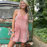 A woman wearing the Pink Garment Washed Cotton Denim Overall Dress in front of a vintage teal Volkswagen bus.