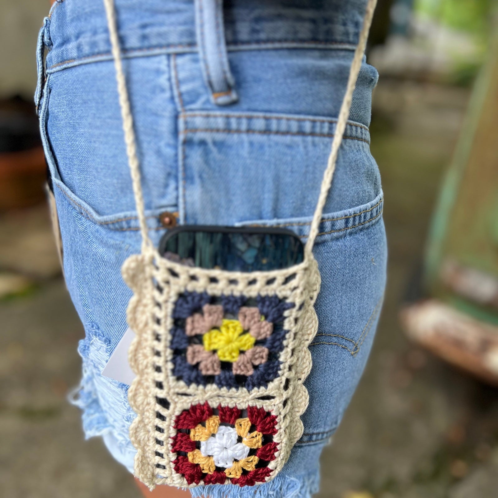 Someone wearing the Handmade Bohemian Crochet Phone Crossbody Bag.