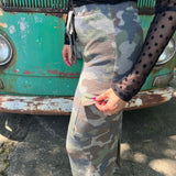 A woman wearing the Camo Cargo Skirt with a black star mesh top.