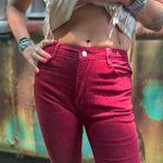 Someone wearing the Wine Soft Corduroy Flared Pants with Distressed Hem and a cream fringe top.