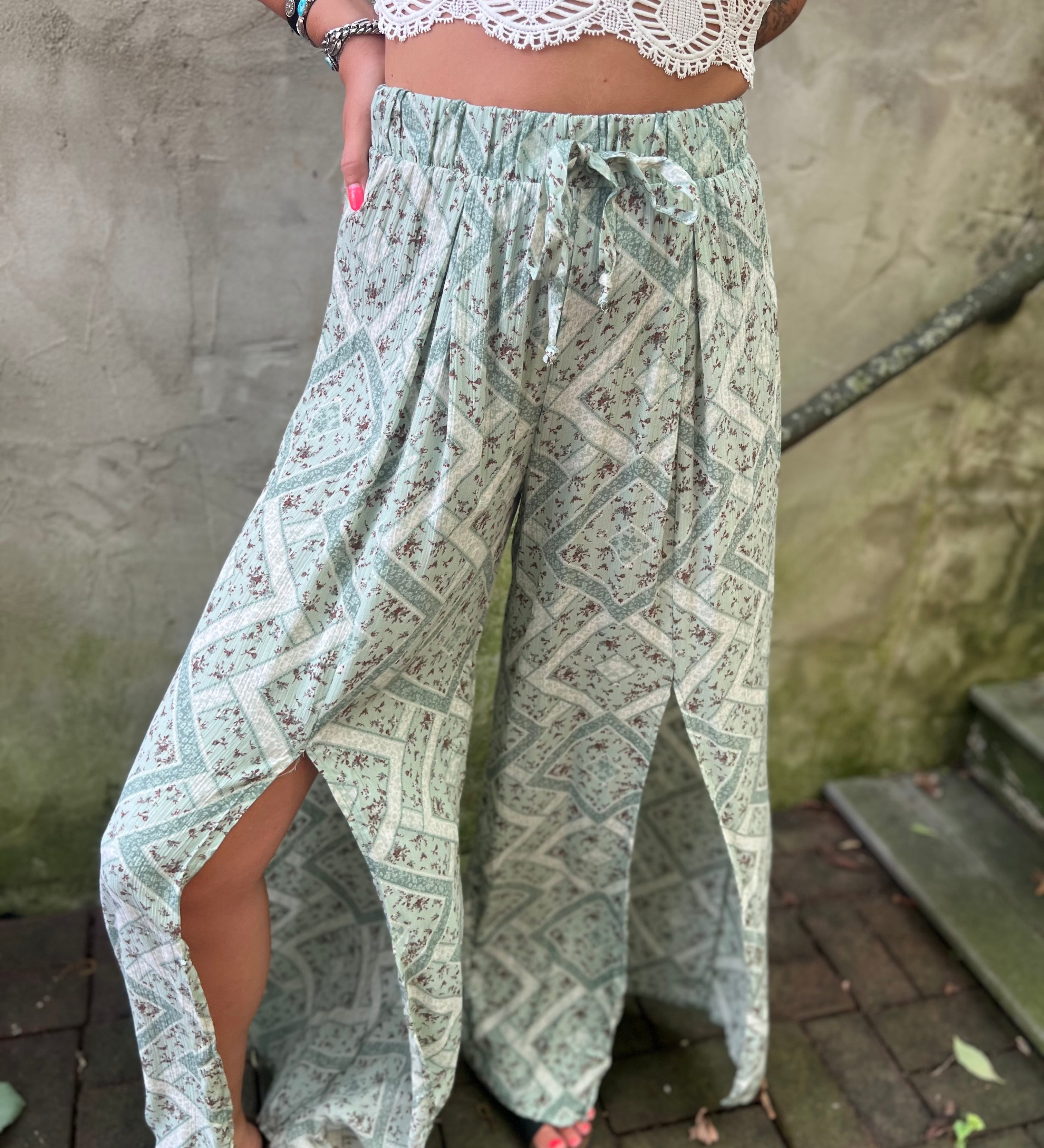 A woman wearing the Sage Linen Pants with Front Slit and a white bralette.