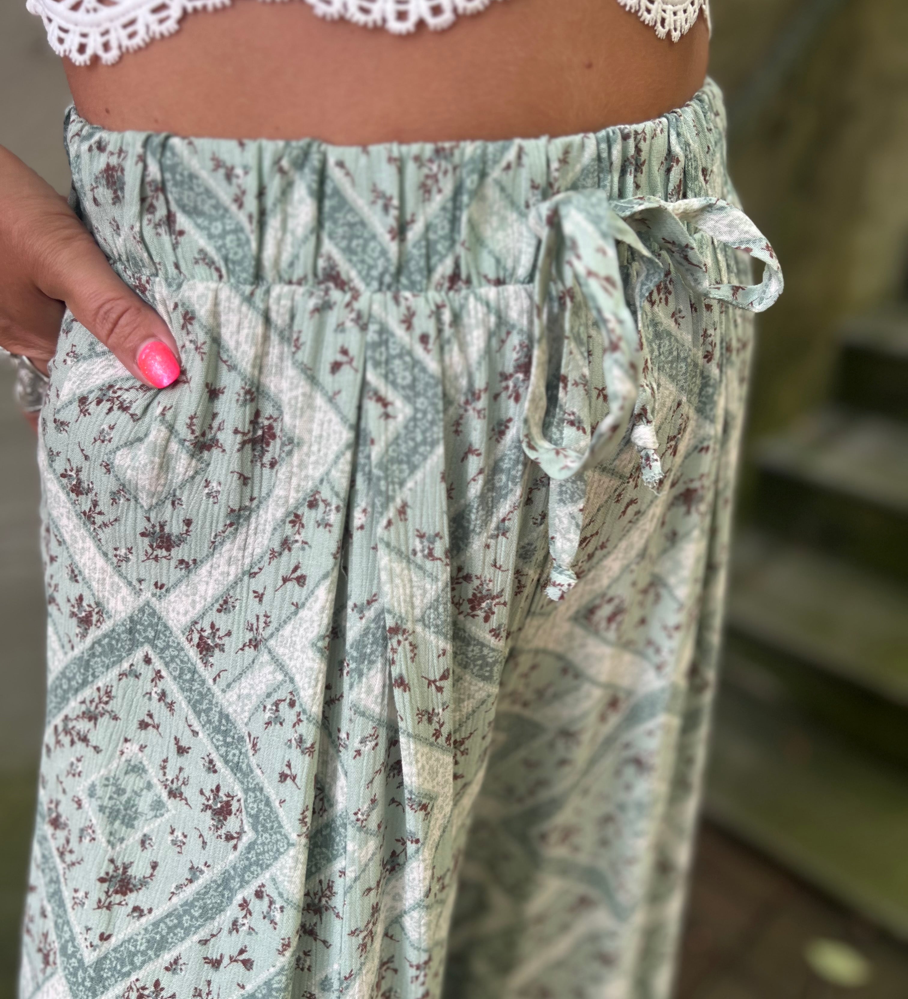 A woman wearing the Sage Linen Pants with Front Slit and a white bralette.