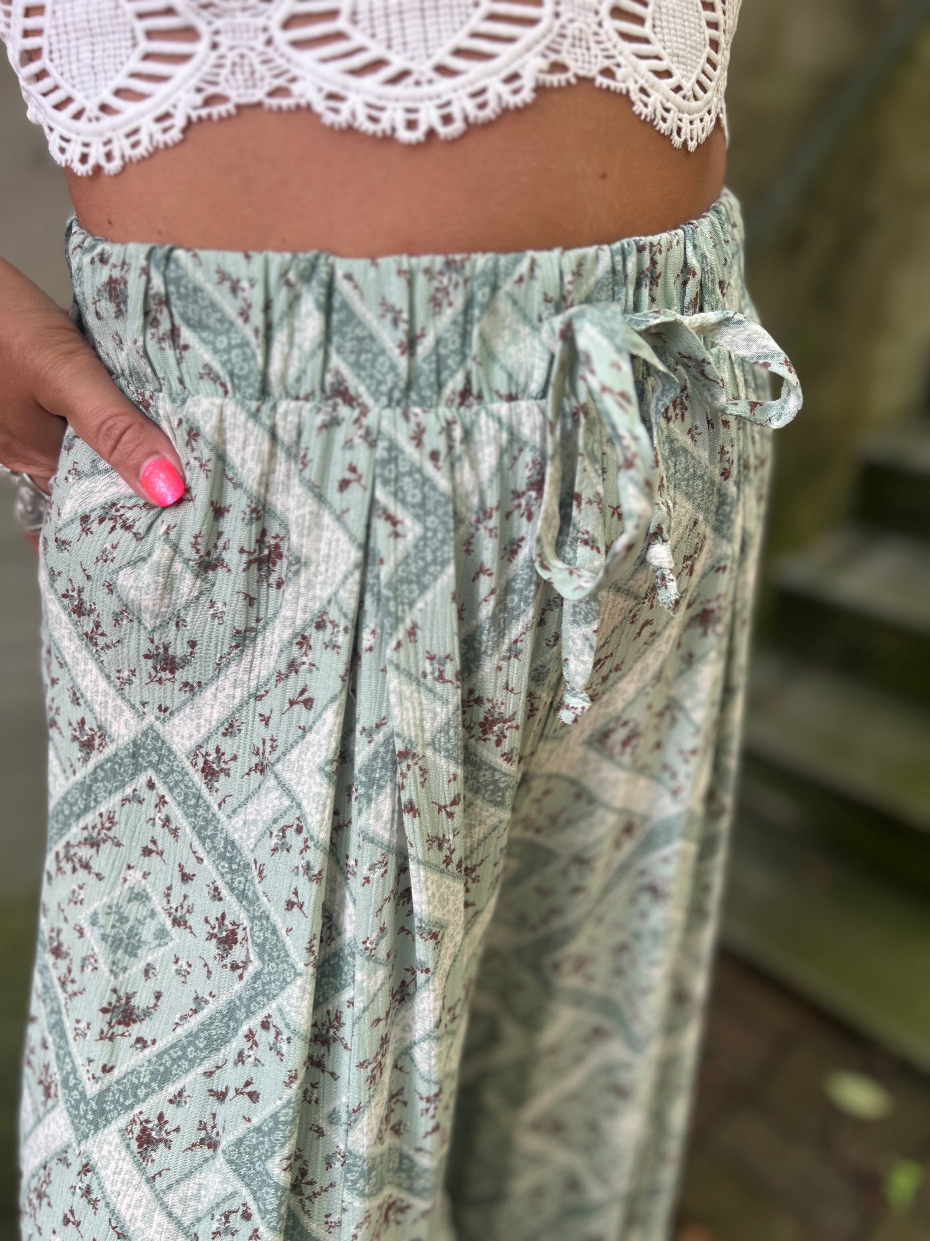 A woman wearing the Sage Linen Pants with Front Slit and a white bralette.
