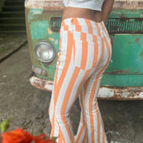A woman wearing the Papaya Striped Washed Denim Bell Bottoms and a white bralette.