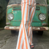 A woman wearing the Papaya Striped Washed Denim Bell Bottoms and a white bralette.