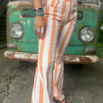 A woman wearing the Papaya Striped Washed Denim Bell Bottoms and a white bralette.
