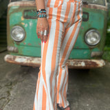 A woman wearing the Papaya Striped Washed Denim Bell Bottoms and a white bralette.