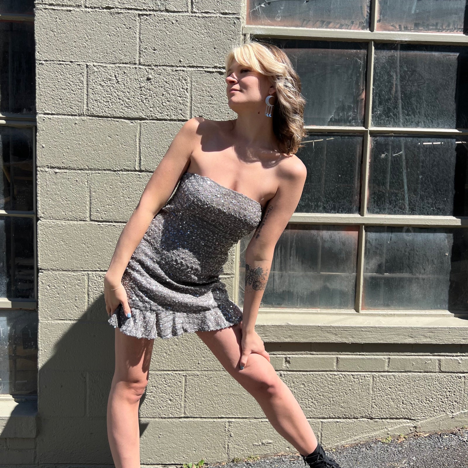 A woman wearing the espresso Sequin Lace-Up Back Strapless Mini Dress.