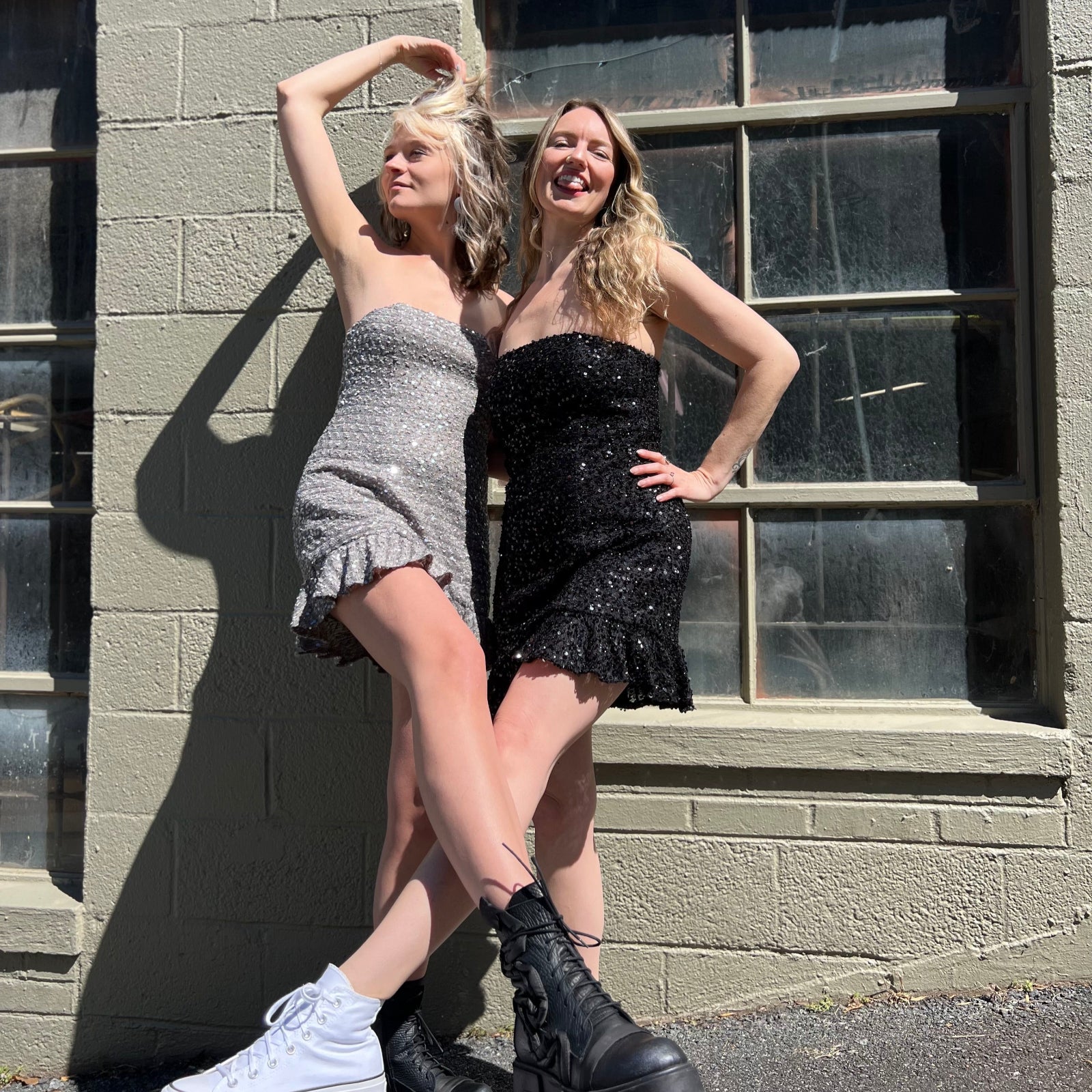 Two women wearing the espresso and black Sequin Lace-Up Back Strapless Mini Dresses.