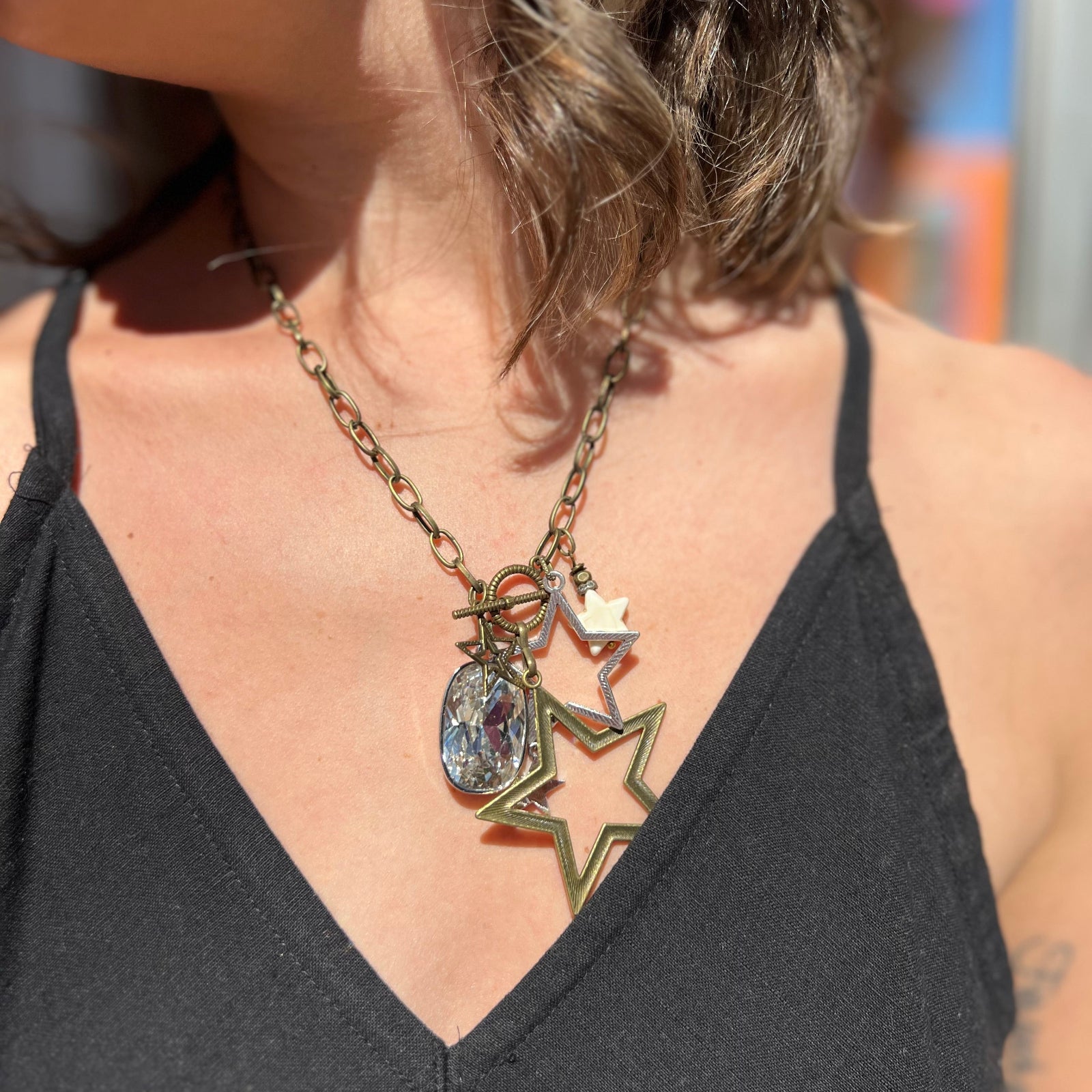 A woman wearing the Gypsy Star 20" Necklace with a black top.