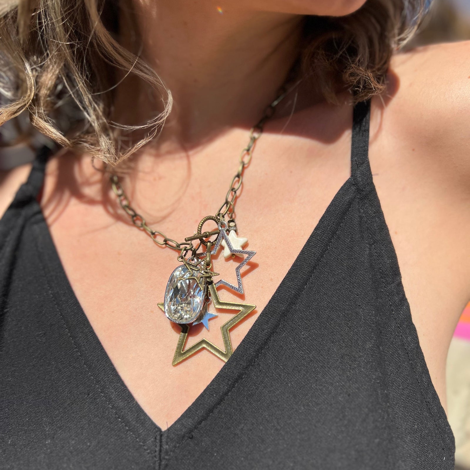 A woman wearing the Gypsy Star 20" Necklace with a black top.