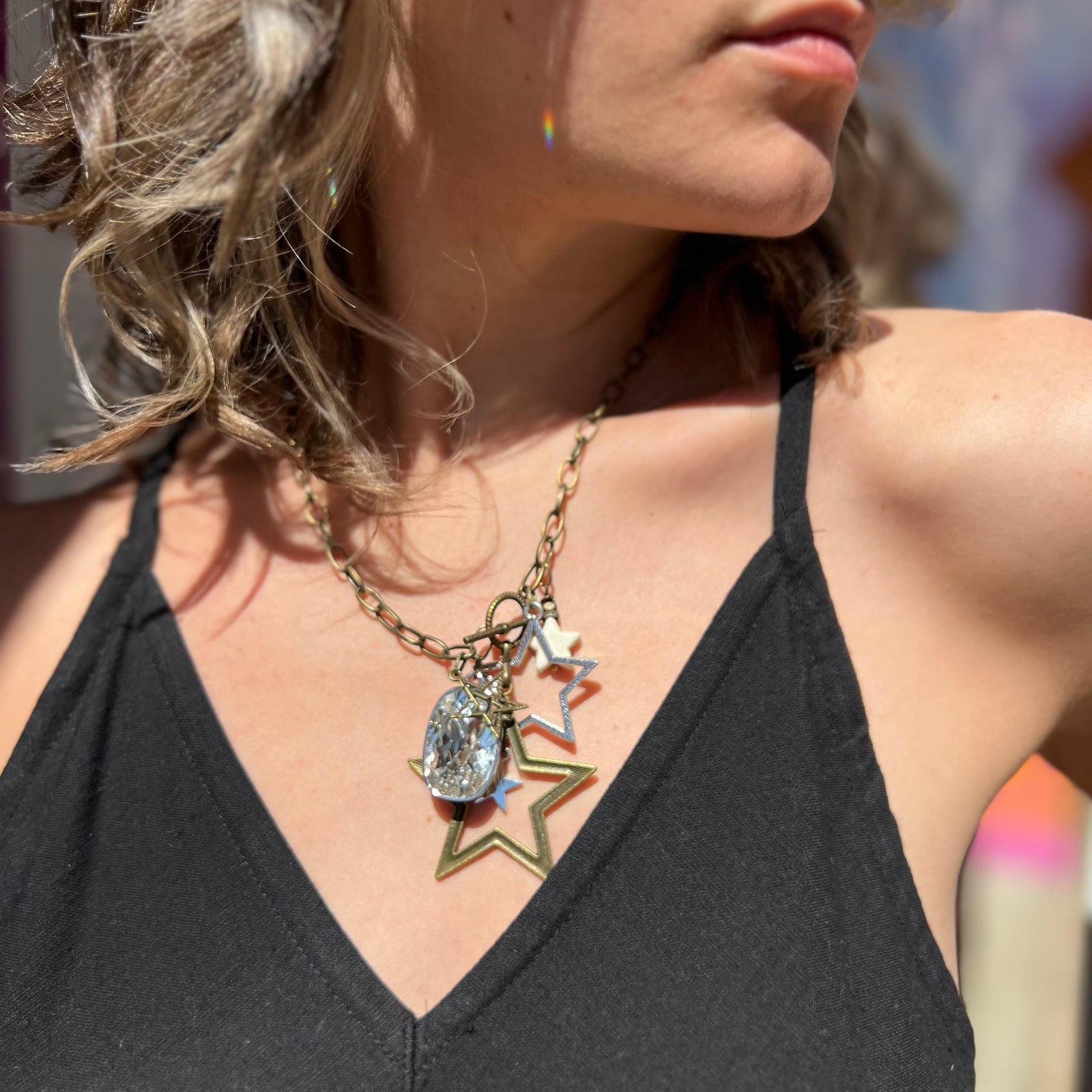 A woman wearing the Gypsy Star 20" Necklace with a black top.