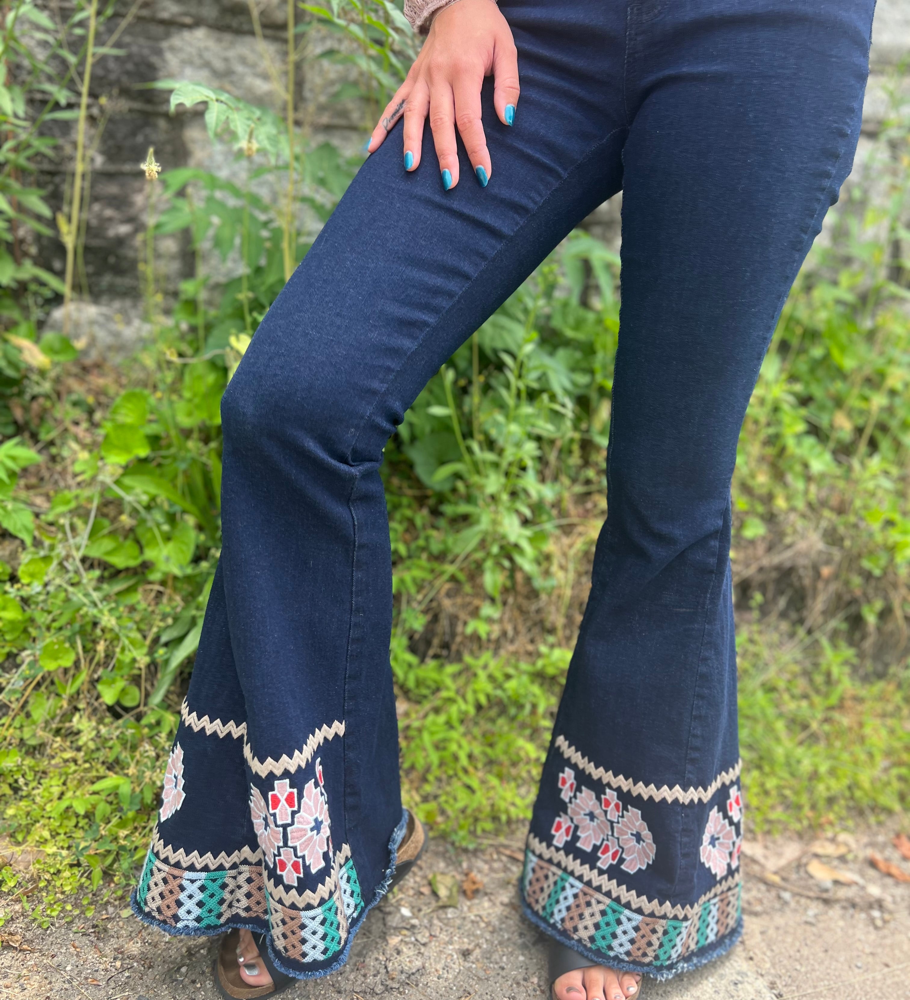 A woman wearing the Dark Denim Bellbottoms with Embroidery Detail.