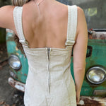 A woman wearing the sand Washed Western Buckle Embroidered Romper in front of a vintage teal Volkswagen bus.