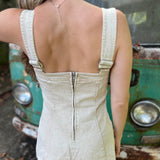 A woman wearing the sand Washed Western Buckle Embroidered Romper in front of a vintage teal Volkswagen bus.