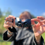 A woman holding the Leather Bat Halloween Hair Clip.
