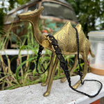 The black Macrame Pendant Choker Necklace on a camel statue.