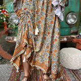 Someone wearing the orange & cream Hippie Floral Cinch Maxi Ruffle Skirt in front of a Volkswagen bus.