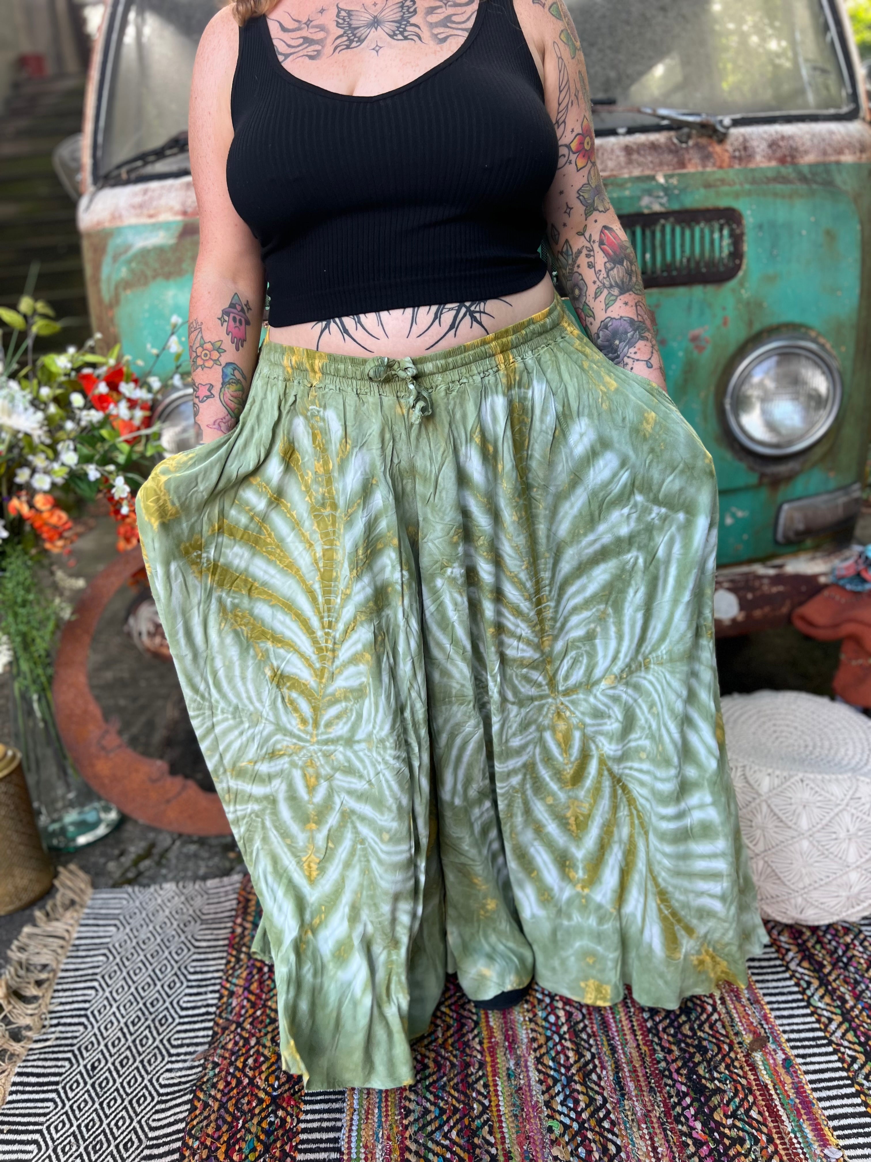 A woman wearing the green Hippie Bohemian Hand Dyed Palazzo Pants in front of a vintage Volkswagen bus.