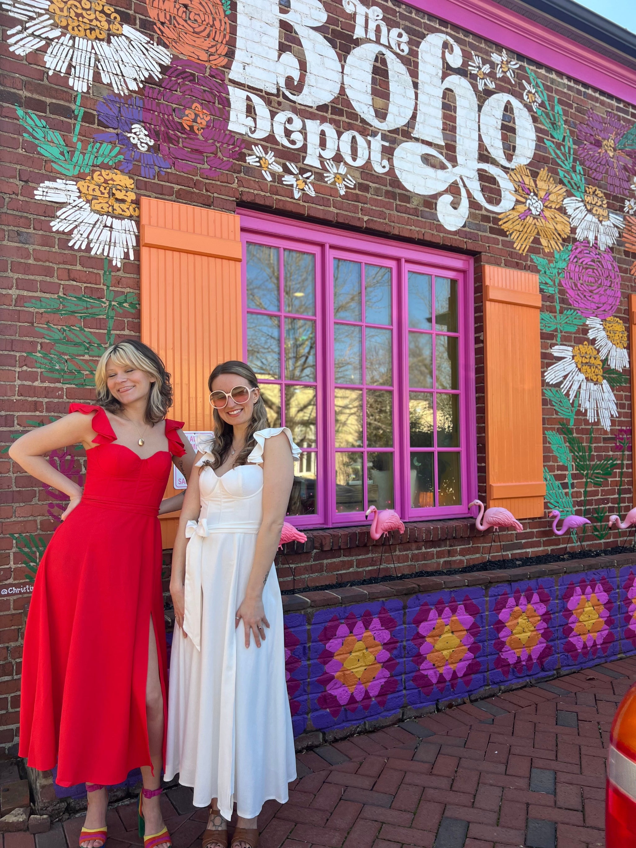 The ivory and red heaven corset flutter dresses in front of the Boho Depot store.