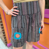 A woman wearing the agate Granny Square Mini Skirt with a tan top.